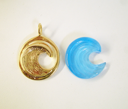 The finished blue topaz carving next to the gold pendant sample.