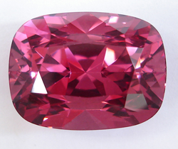 This shows a very beautiful cushion shape raspberry pink Spinel that is 26.60 carats.