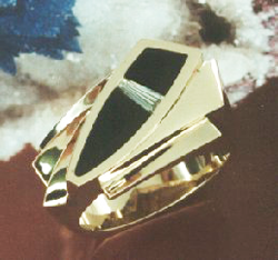 Ring with a black Onyx inlay on each side of a tapered baguette diamond.