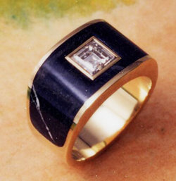 Ring with an arch of greenish Granite and a square hole in the center with a large square diamond set in a white gold tube.