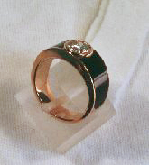 A ring with a round diamond set in the middle and black Jade coming down each side of the ring.