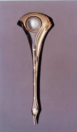 A long gold pin with a large round pearl set at the top and a row of 6 Black Jade inlays which come to a point at the bottom.