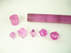 Photo shows 5 pink faceted geometric shapes made from synthetic sapphire.