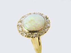 Photo of an Opal ring surrounded by Diamonds with a piece of the Opal missing.