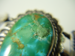 Shows the same Turquoise cabochon with a mound of filler we have put in the cracks and pits.