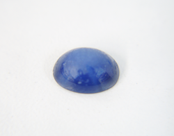 Photo of a blue Linde Star Sapphire cabochon which needs to be re-polished and is very dull looking.