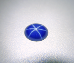 Photo of a blue Linde Star Sapphire cabochon which has been re-polished and now shows a nice sharp star.