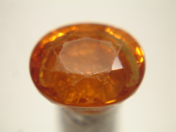 An oval orange Mandarin Garnet which has been re-polished.