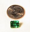 Photo of an Emerald next to a dime.