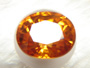 Photo of an oval orange garnet.