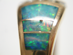 Photo shows a ring with an Opal inlay which has a large chip in it.