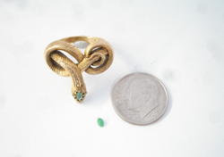 A snake ring with a tiny marquise Jadeite cab sitting next to it.