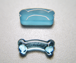 Shows the finished gem carving of a blue Topaz dog bone.