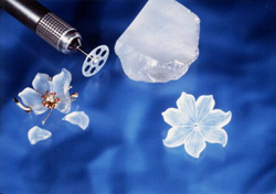 Picture showing a broken Quartz flower carving and a new one just like the broken one and also the carving tool that was used to make it.