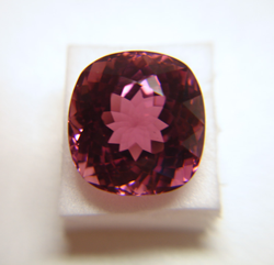 Photo of a cushion shape pink Tourmaline which has a window and needs to be re-faceted.
