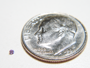 Small photo of a tiny faceted gemstone.