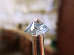 Shows the pavilion of the Aquamarine with almost all of the facets polished.
