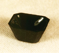 A black Jade which have been carved into a octagonal block with a dish in the middle.