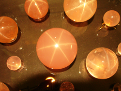 Shows several star rose Quartz spheres being displayed at the Denver gem show in September of 2011.