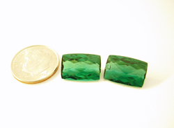 Shows a matched set of green Tourmaline cushion cuts.