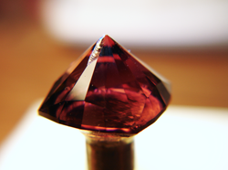 Photo of a pink Tourmaline with a chip on the pavilion.