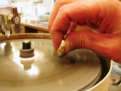 Shows me trimming down the tops of the Opal to make the inlay flush with the top of the ring.