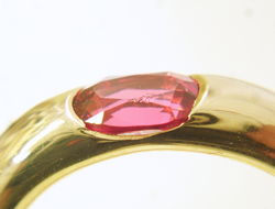 Photo of a pink Spinel with chips on the table and star facets while it is in the ring.